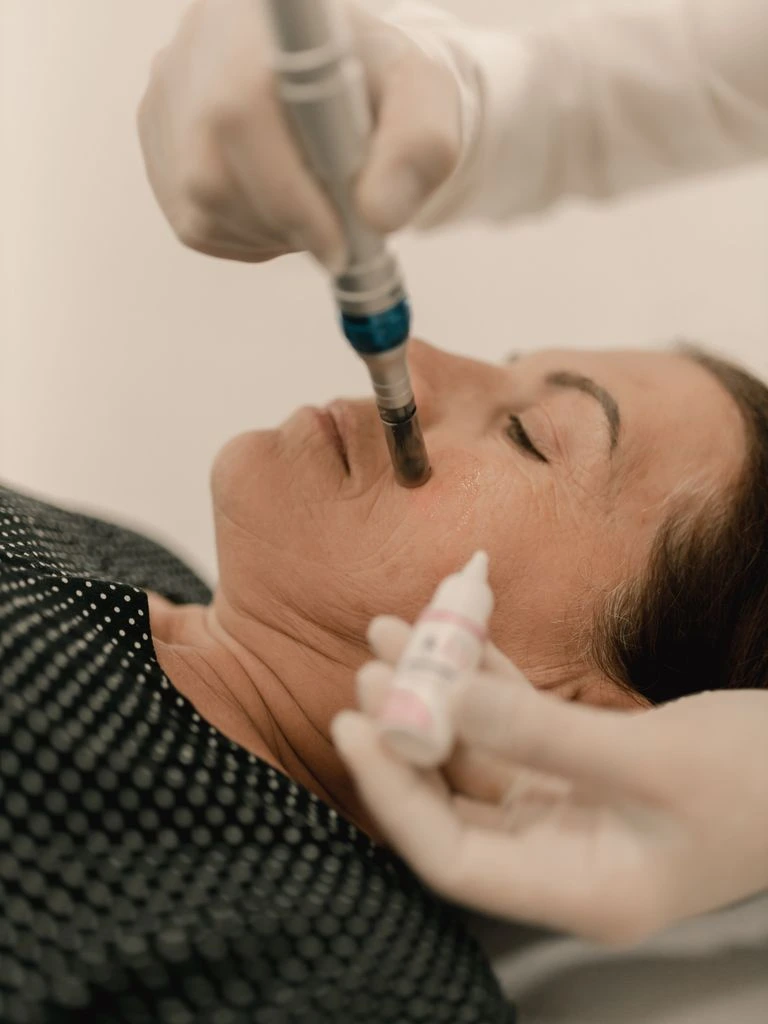A clinician calibrates a handheld phototherapy device during a clinical examination.